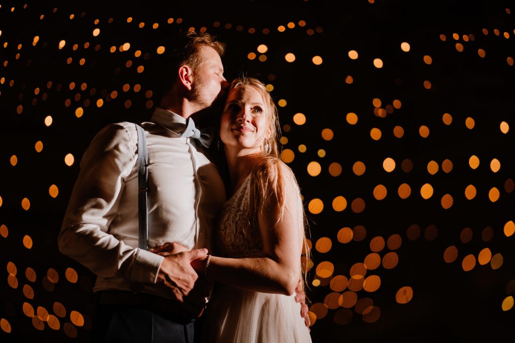 Nächtliches Portrait eines Brautpaars mit funkelnden Lichten in der Hochzeitslocation Landhaus Westerhof